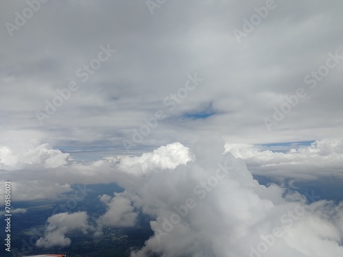 Clouds above the ground, view of the sky from the window of an airplane.