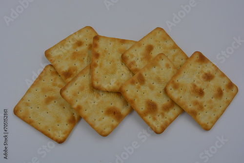 Branded, factory-made biscuits, large thin salted crackers are arranged on a white background.