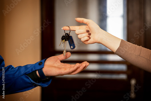 The hand of a woman handing over the keys to the apartment to the new owners. Close-up.