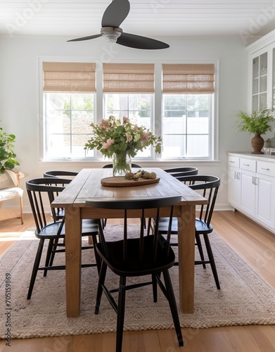 Black spindle chairs with a wood table and a jute rug in a bright dining room