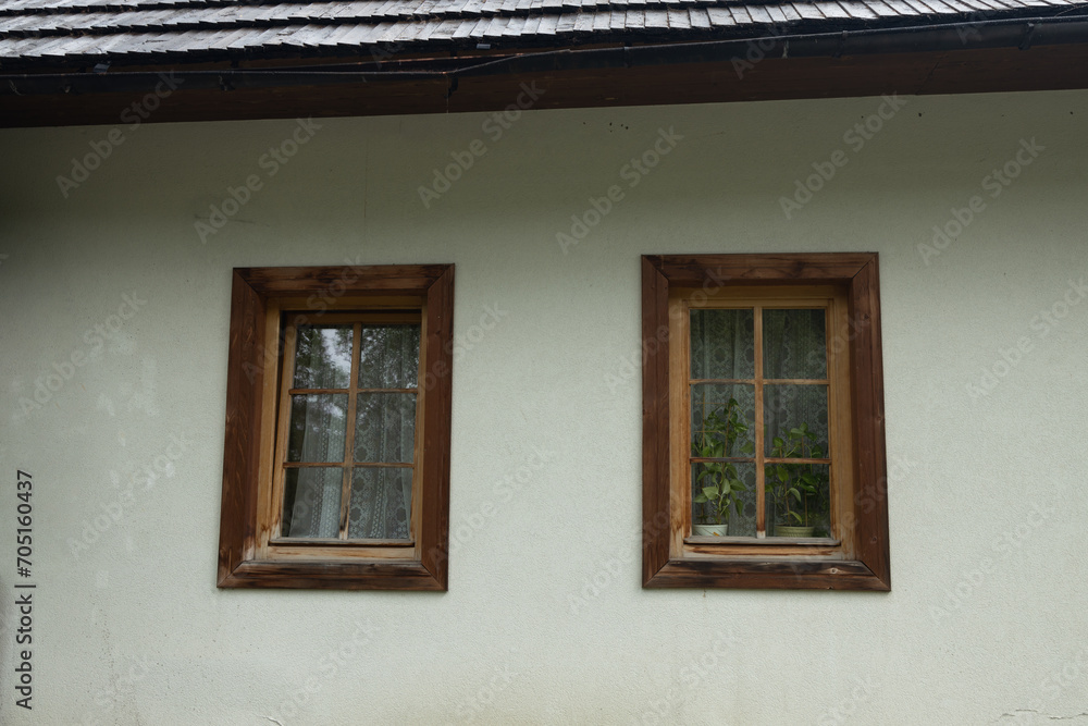 Two old windows with wooden frames, a fragment of the facade of an old building in Tatra Mountains, Poland. High quality photo