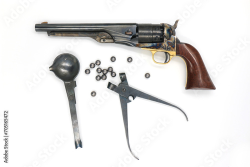 Black powder percussion revolver Colt 1860 Army and the equipment such as a spoon for melting lead, a mold for bullets and lead bullets on a white background. Left side. photo