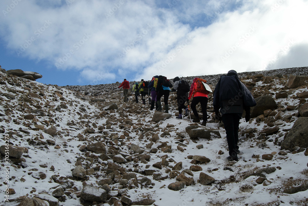 A group of people hiking in mountainous terrain with small backpacks