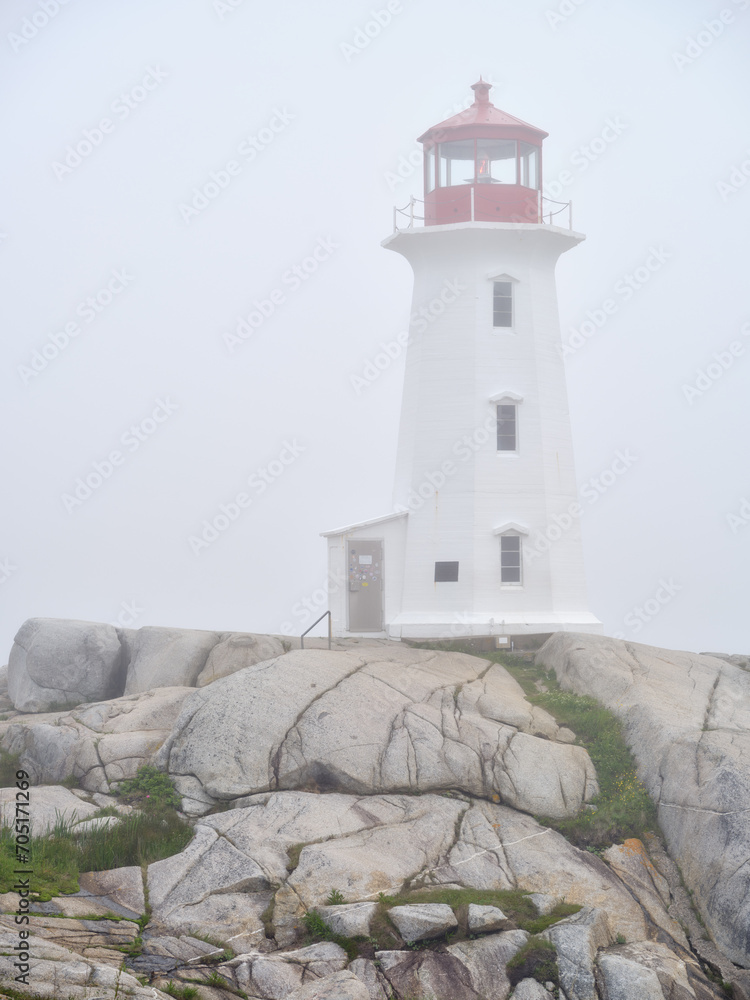 The beautiful Peggys Cove Lighthouse on the coast of Nova Scotia in thick fog