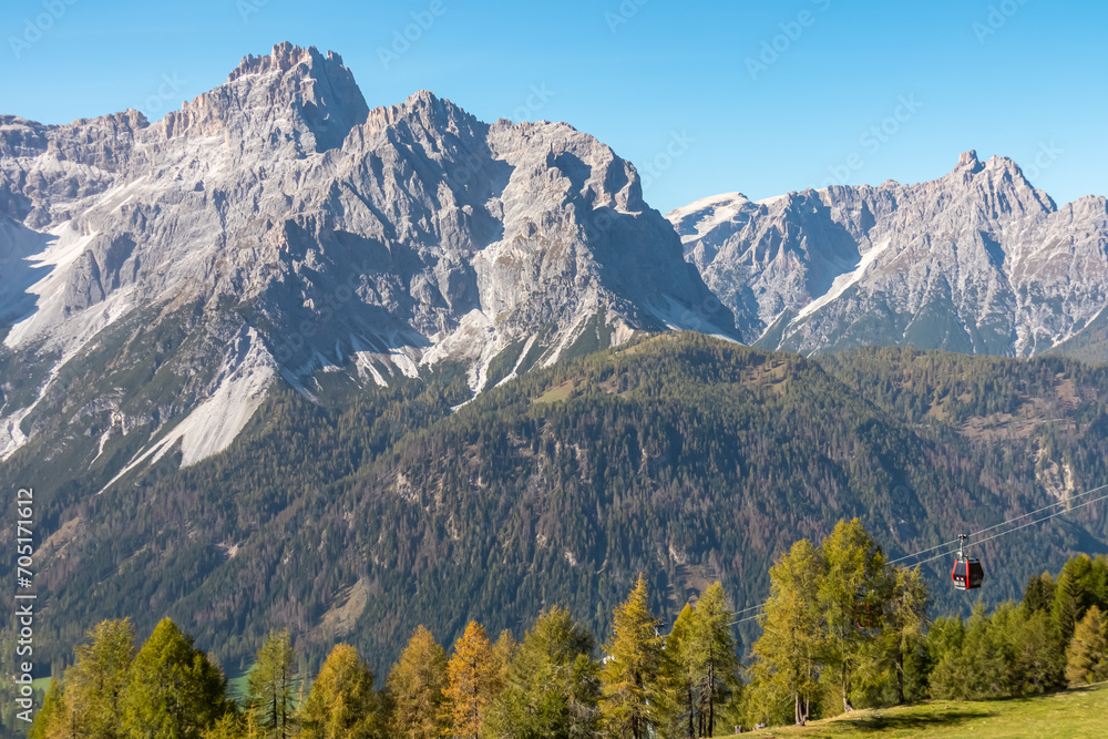 Fototapeta premium Cable car Tre Cime (Drei Zinnen) with scenic view of ridge summit Dreischusterspitze in majestic mountain range of untamed Sexten Dolomites, South Tyrol, Italy, Europe. Hiking concept Italian Alps