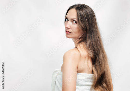 Portrait of attractive woman in white towel on white background. Sauna, Spa, Beauty