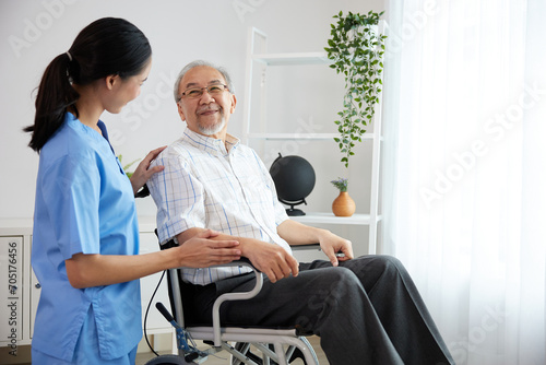 nurse or caregiver beside elderly man sitting on wheelchair at home