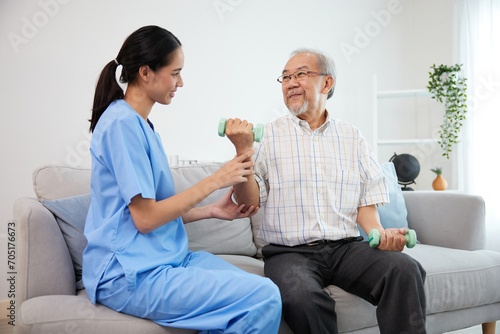 nurse or caregiver helping elderly patient to physiotherapist and exercise for rehabilitation at home
