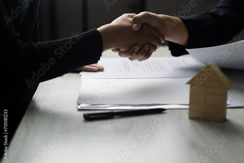 Shake hand Real estate brokerage agent Deliver a sample of a model house to the customer, mortgage loan agreement Making lease and buy and sell house And contract home insurance mortgage loan concept