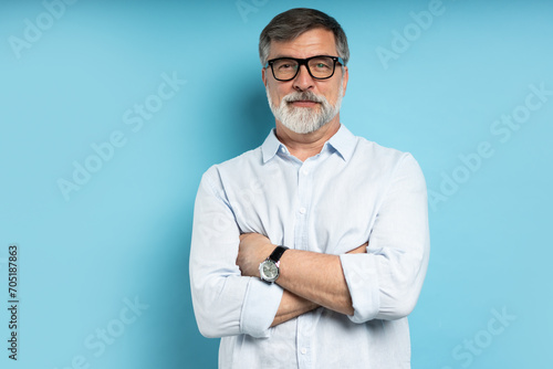 Φωτογραφία Bearded middle-aged man wearing glasses posing over blue studio background