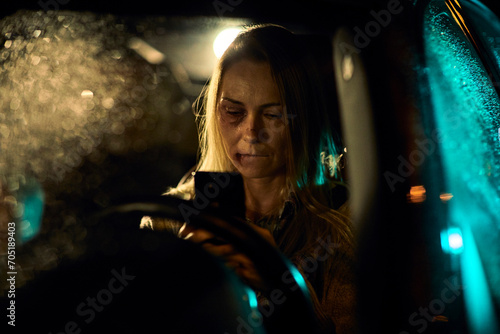 Female victim of domestic violence making phone call in car