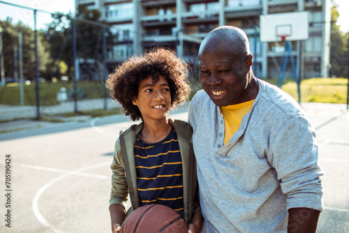 Father and son bonding over basketball in park