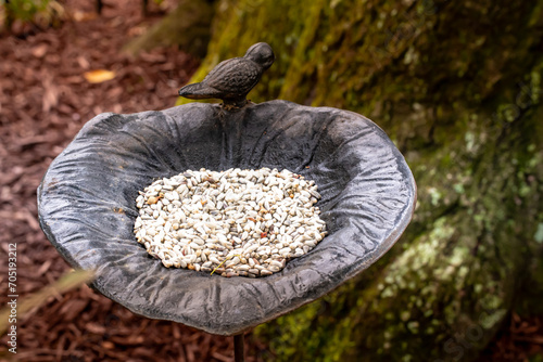 Birdfeeder statue filled with bird seed, garden ornament