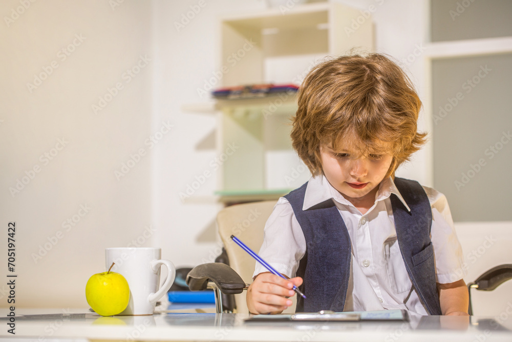 Young business boy. Little boss in office. Young businessman using a laptop. Child handsome boy in office. Seriously little children business man. Education, children, technology. Boring job Young business boy. Little boss in office. Young businessman using a laptop. Child handsome boy in office. Seriously little children business man. Education, children, technology. Boring job