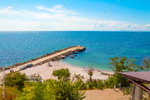 Boats mooring on sea in Nessebar  Bulgaria. Summer sunny landscape with moored woods boat at quay by blue sky. Public beach.