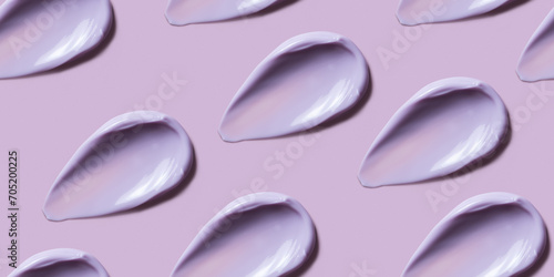 Seamless pattern of violet cosmetic cream smear on pastel pink background. Beauty product texture, light purple smudge such as body butter, lotion, conditioner, shower gel or shampoo, top view