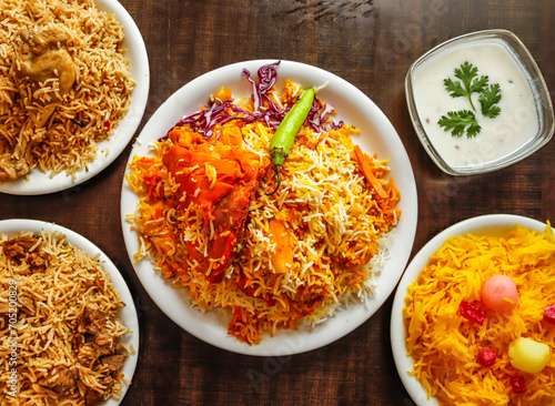 Assorted biryani, pulao with beef, chicken and zarda color ful rice served in plate isolated wooden background top view indian sweet and pakistani dessert food photo