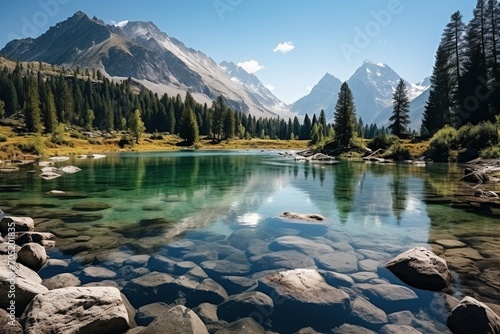 Stunning mountain lake landscape with crystal clear water and snow capped peaks in the distance © duyina1990