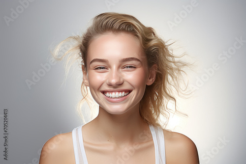 blonde girl smiling, on gray background