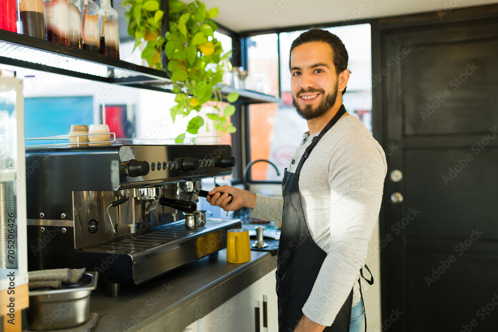 Attractive latin man happy about working in the coffee shop