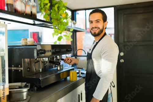 Attractive latin man happy about working in the coffee shop