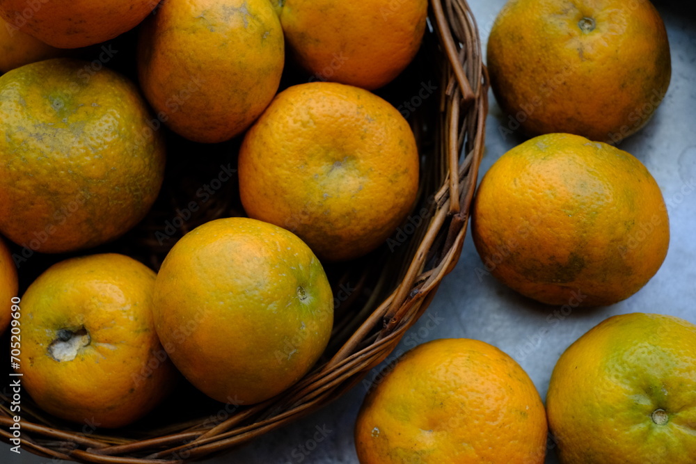 Close up shot of Kinnow Oranges in wooden basket