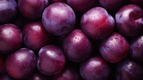 Background texture of plums. A lot of ripe purple plums background, top view. Ripe juicy plum close-up.
