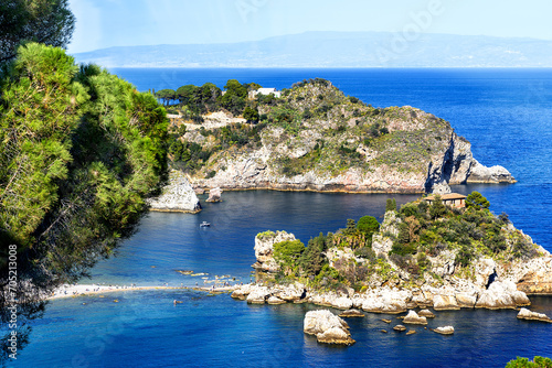 View from above under an intensely blue sky of the stunning seascape with Isola Bella at the foot of Taormina, a destination for many tourists photo