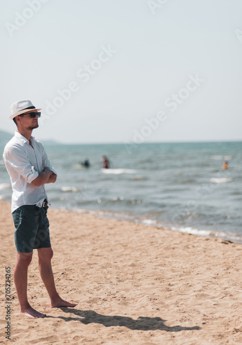 A tourist at the beach is looking the sea 