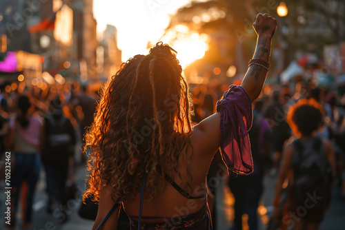 Generative AI back view image of an unrecognizable Black woman with curly hair and dreadlocks, raising her fist at a feminist protest at dusk photo