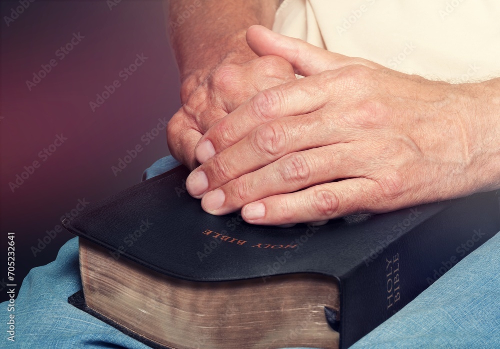 Man praying hold holy bible book