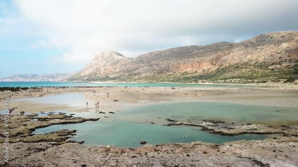 Flyover of greek beach with tourists and mountains in the background Flyover of greek beach with tourists and mountains in the background