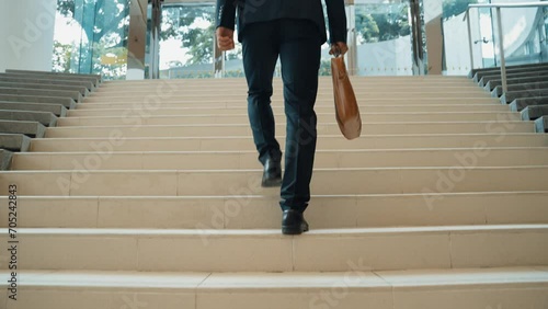 Closeup of business man leg go up the stairs. Successful man going up the stairs while explore a new thing. Traveling, getting a promotion, finding a new job, increasing skill. Back view. Exultant. photo