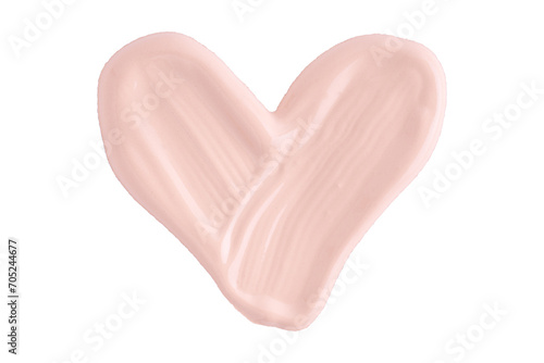 A smear of foundation cream or concealer in the shape of a heart isolated on white background, macro. Texture of cosmetic foundation or beige cream smudge, smear, stroke. photo
