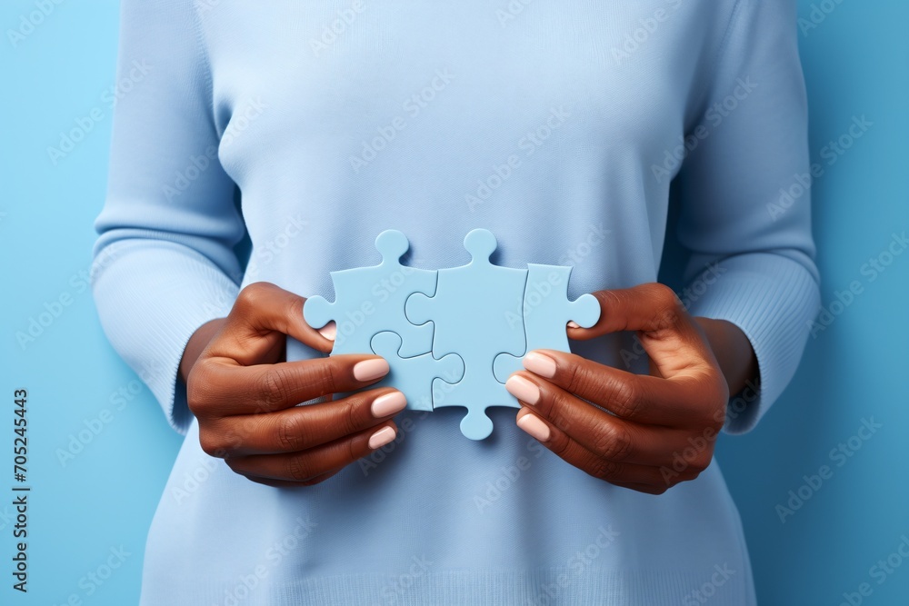 Black woman holding two puzzle pieces Black woman holding two puzzle pieces