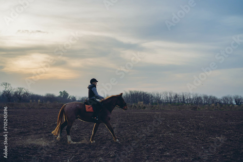 woman on her horse riding through the Argentinean countryside at sunset. Copy space