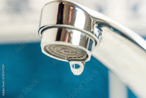 A drop of water drips from a leaky faucet