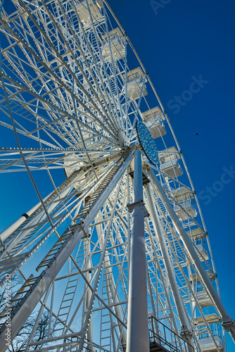 Low-angle view of a Ferris wheel against a clear blue sky in Lancaster.
