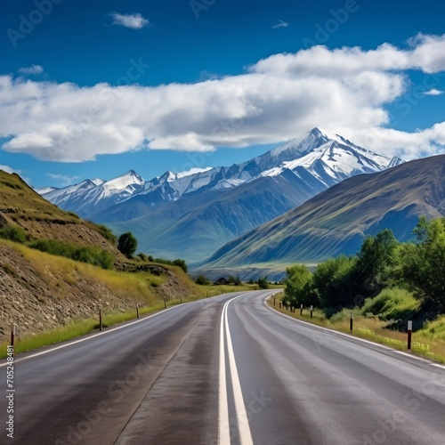Beautiful mountain road landscape with snow capped mountains in distance,