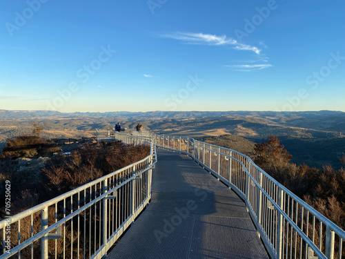 Bridge in the mountains. Belvedere on a boardwalk at the top of the summit in the Blue mountain region, Australia. People watching the panoramic view at sunset.