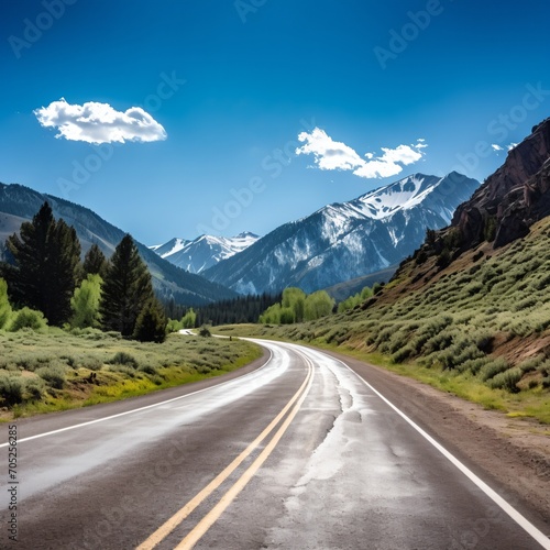 Scenic mountain road with snow capped mountains in the distance