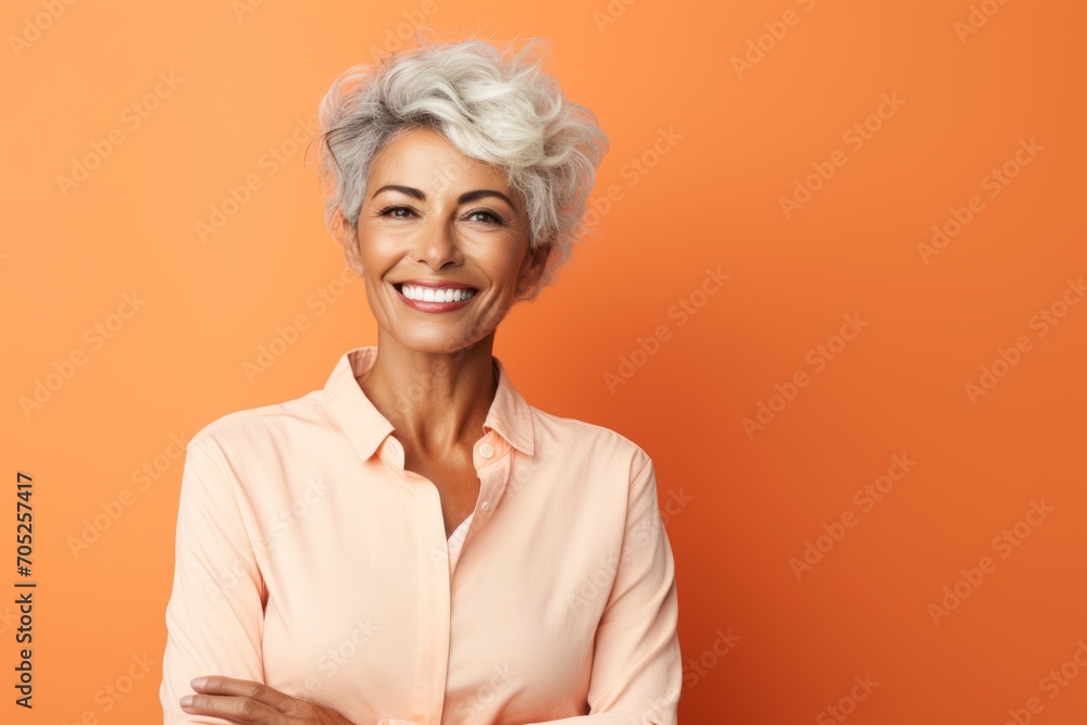 Portrait of beautiful smiling senior woman with short grey hair on orange background Portrait of beautiful smiling senior woman with short grey hair on orange background