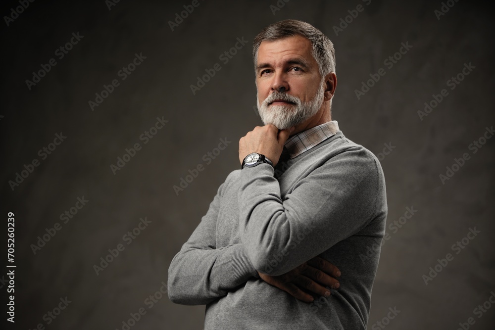 Portrait of happy casual mature man smiling, senior age man with gray hair, Isolated on dark gray background Portrait of happy casual mature man smiling, senior age man with gray hair, Isolated on dark gray background