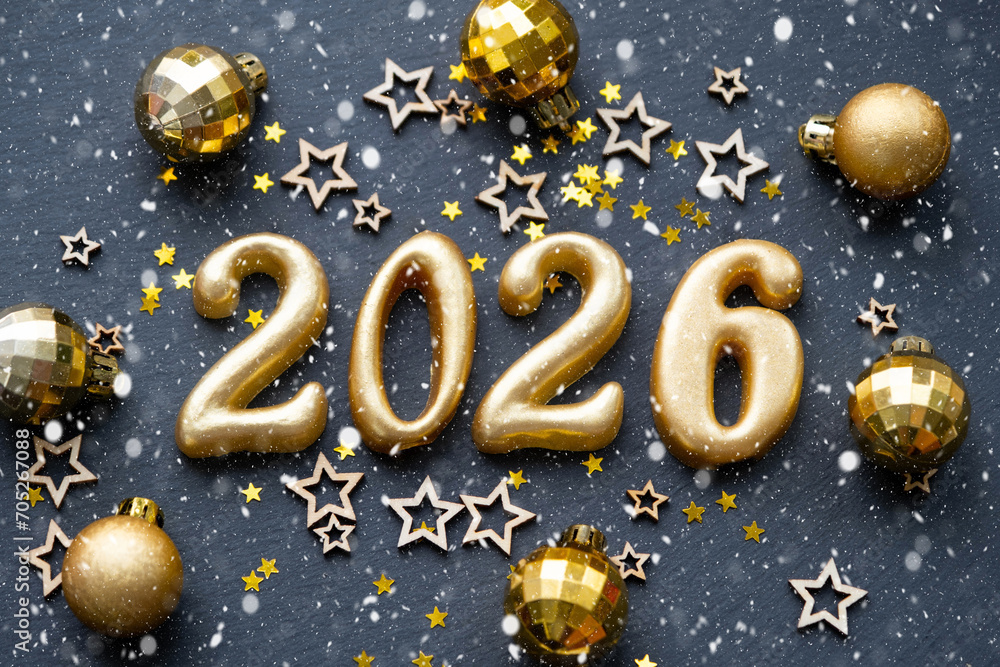 The golden figures 2026 made of candles on a black stone slate background are decorated with a festive decor of stars, sequins, fir branches, balls and garlands. Greeting card, happy New Year. The golden figures 2026 made of candles on a black stone slate background are decorated with a festive decor of stars, sequins, fir branches, balls and garlands. Greeting card, happy New Year.