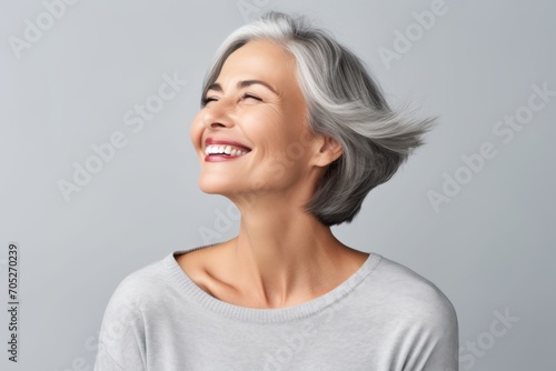 Happy smiling senior woman with grey hair and closed eyes over grey background
