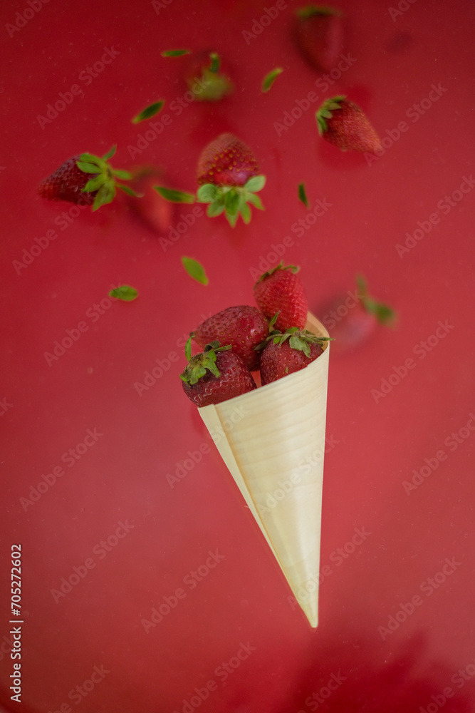 Strawberry levitating on a red background. A bowl of falling strawberries Strawberry levitating on a red background. A bowl of falling strawberries