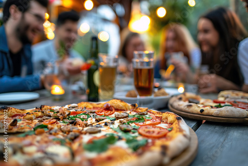 Group of People Sitting Around a Table With Pizza