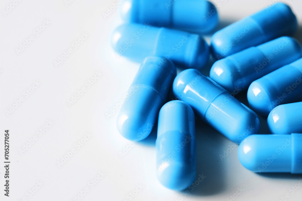Medicine background. Blue pills isolated on white. Pile of capsules. Tablets background. Vibrant vivid color drugs. Antibiotics background. Group of drugs. Empty copy space medical background.