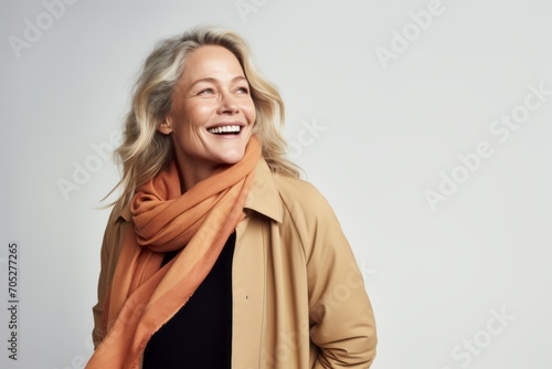 Portrait of a happy senior woman in autumn coat and scarf smiling at camera © Igor