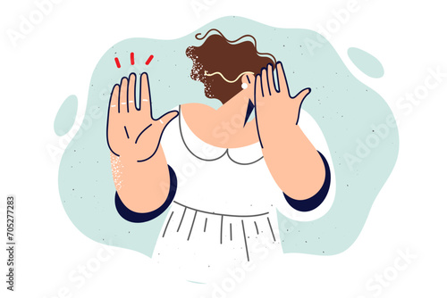Woman victim of violence covers face with hand and shows stop gesture, calling to fight bullying